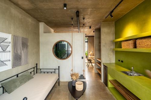 a room with a bed and a sink and a mirror at The Digital Nomad Den in Jacó