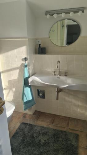 a bathroom with a sink and a mirror and a toilet at Ferienwohnung Lottchen in Schwerin