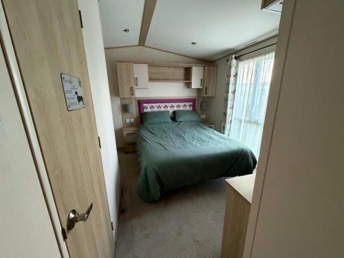 a small bedroom with a bed in a small room at 6 berth caravan in Ingoldmells opposite beach in Ingoldmells