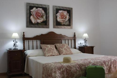 a bedroom with a bed with two pictures on the wall at Casa Rural Galatea especial Grupos in Ossa de Montiel