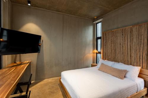 a bedroom with a bed and a flat screen tv at The Terrace Retreat in Jacó