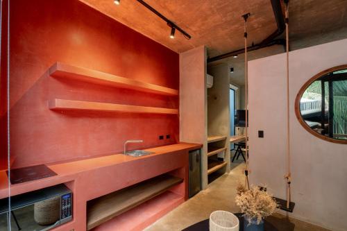 a kitchen with a sink and a red wall at The Terrace Retreat in Jacó