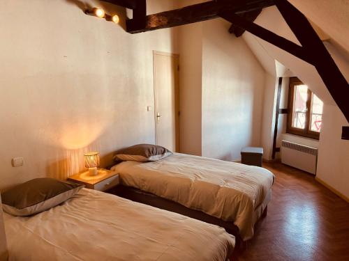 a bedroom with two beds and a lamp on a table at Levroux - maison 4-6 pers - cour privee in Levroux
