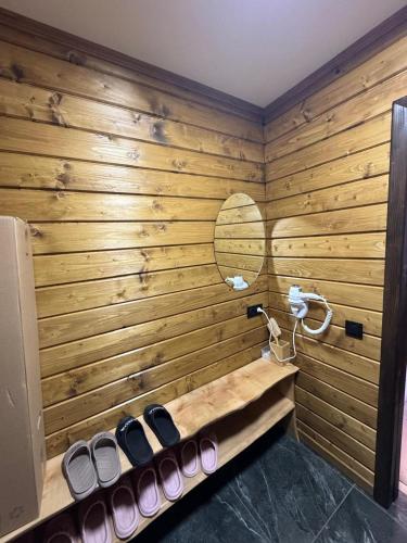 a room with a wooden wall with a row of shoes at Вича in Sasivka