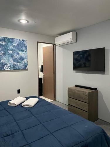 a bedroom with a blue bed and a dresser at AR SUITES DEPARTAMENTO CENTRO 3 in Zamora de Hidalgo