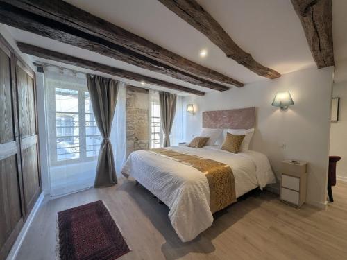 a bedroom with a bed and a large window at La demeure Langroise in Langres