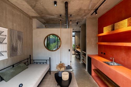 a room with a bed and a sink and a mirror at The Penthouse Perch in Jacó