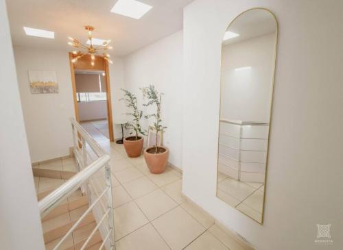 a hallway with a mirror and a staircase at AR Suites Casa Master Suite Nueva Luneta in Zamora de Hidalgo