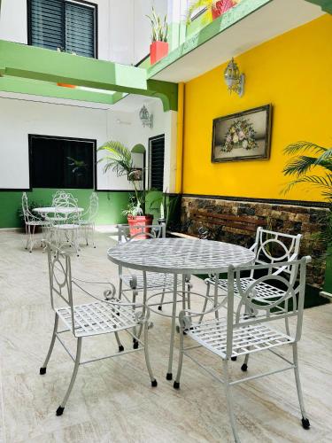 une table et des chaises dans une pièce avec un mur jaune dans l'établissement Hotel Valladolid, à Valladolid
