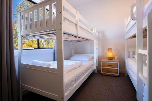 two bunk beds in a room with a window at Stunning Water Views 2 in Jindabyne