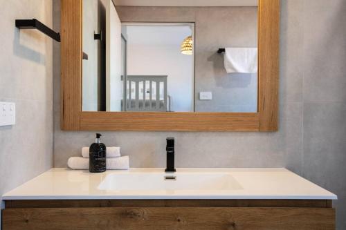 a bathroom with a white sink and a mirror at Stunning Water Views 2 in Jindabyne