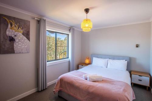 a bedroom with a bed with a deer picture on the wall at Stunning Water Views 3 in Jindabyne