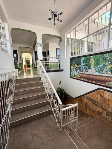 Hotel Valladolid في فالادوليد: ردهة بها درج ولوحة كبيرة على الحائط