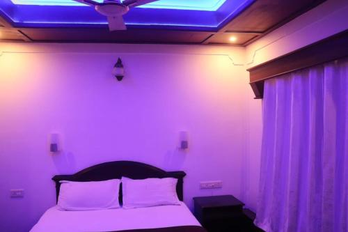 a bedroom with a bed with a blue ceiling at Sacred River Houseboats in Alleppey