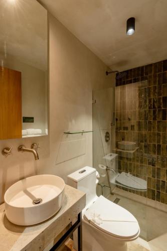 a bathroom with a toilet and a sink and a shower at The Sunset Deck in Jacó