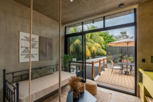 a room with a porch with a swing and a patio at The Sunset Deck in Jacó