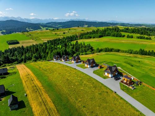 an aerial view of a village in a green field at Osada Dursztyn- Przystanek Podhale in Białka Tatrzańska