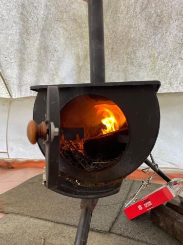 a stove with a fire inside of it at Happy Meadows - Mushroom Street in Long Stratton