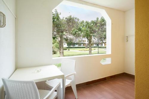 a room with a table and chairs and a window at Golden Club Cabanas in Cabanas de Tavira