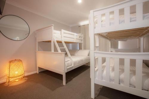 a bedroom with two bunk beds and a mirror at Mountain Oak 2 Jindabyne in Jindabyne