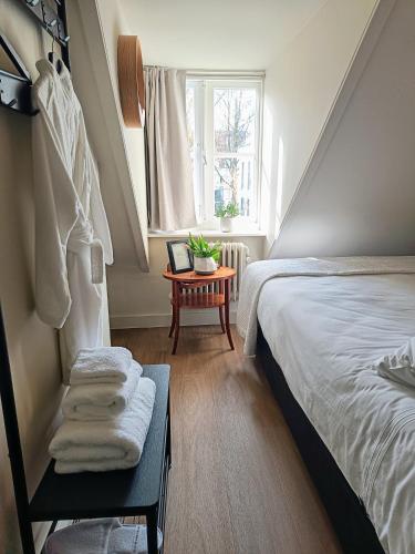 a bedroom with a bed and a window and a table at Boutique Apartment Perenne in Maastricht