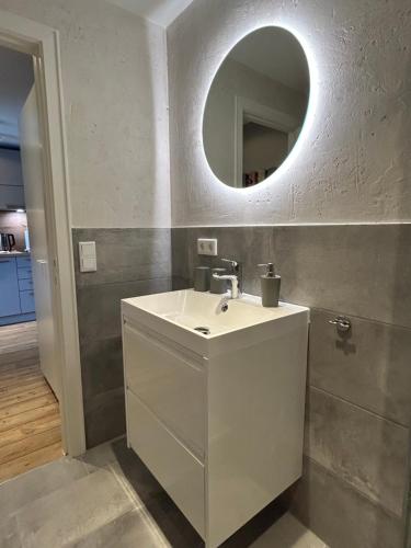 a bathroom with a white sink and a mirror at Mittendrin 102 in Sylt