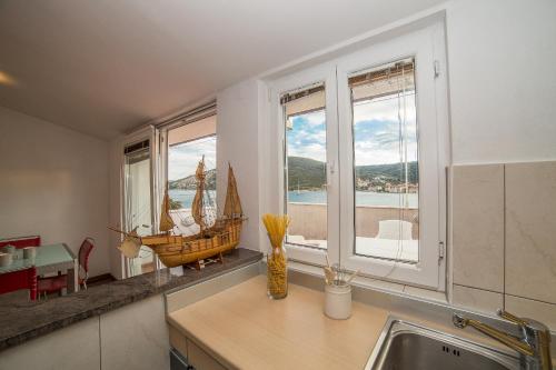 a kitchen with a window with a boat on the counter at Villa Albatros in Vinišće
