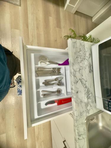 an open refrigerator with utensils in it at Airport Getaway- 4 mins from Airport in Dieppe