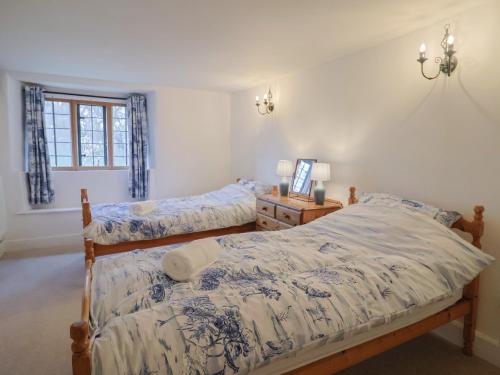 a bedroom with two twin beds and a window at Manor Cottage in Ilminster