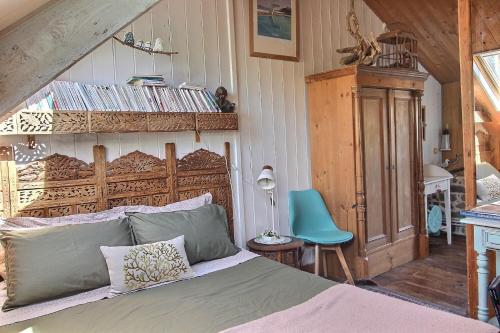 a bedroom with a bed and a blue chair at Rue des dolmens in Saint-Quay-Portrieux