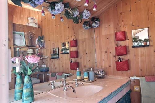a bathroom with a sink and flowers in a room at Rue des dolmens in Saint-Quay-Portrieux