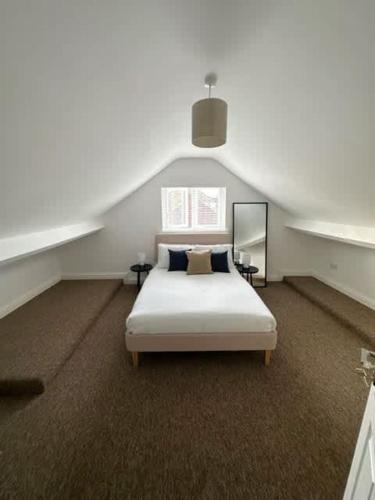 a bedroom with a white bed in a attic at Spacious 6-Bed Home With 4 Parking Spaces in Oxford