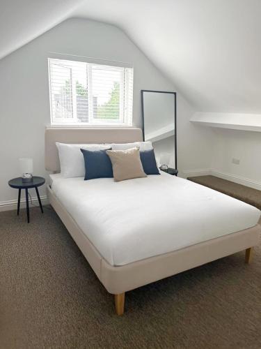 a bedroom with a large white bed with pillows at Spacious 6-Bed Home With 4 Parking Spaces in Oxford