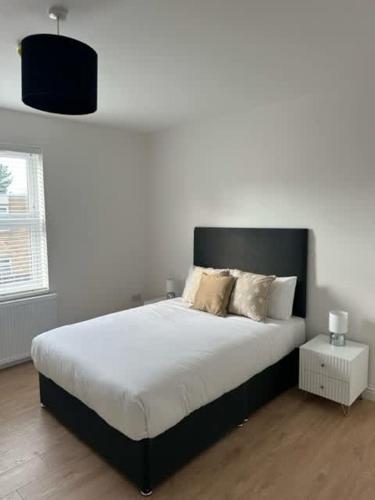 a bedroom with a large bed with white sheets and pillows at Spacious 6-Bed Home With 4 Parking Spaces in Oxford