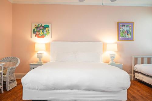 a bedroom with a large white bed with two lamps at King Suite at Curry Mansion with Heated Pool! in Key West