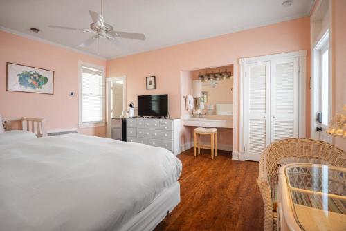 a bedroom with a bed and a desk with a television at King Suite at Curry Mansion with Heated Pool! in Key West