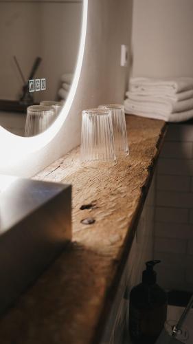two wine glasses sitting on a counter in front of a mirror at Momento Heidkrug in Lüneburg
