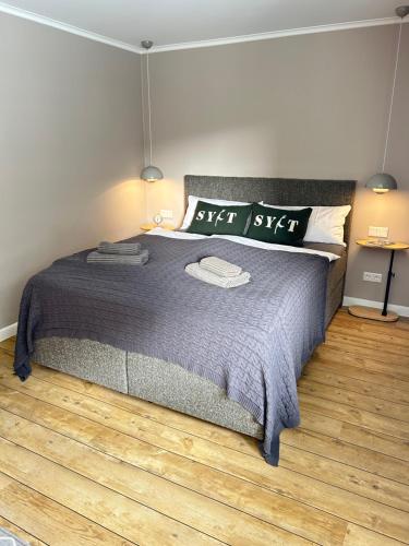 a bedroom with a large bed and a wooden floor at Mittendrin 102 in Sylt