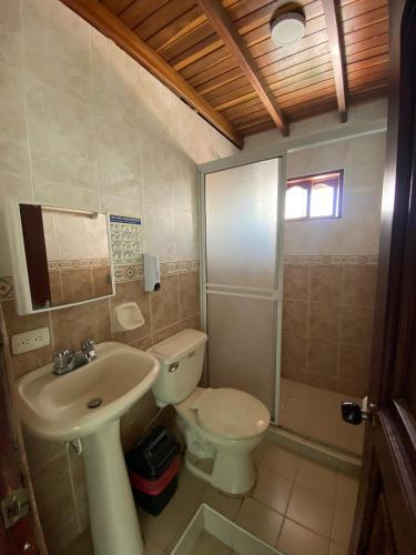 a bathroom with a toilet and a sink at Hotel Rodadero Relax in Gaira