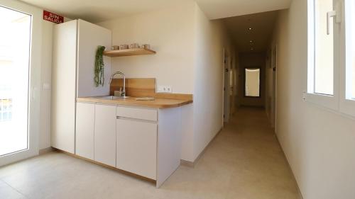a kitchen with a counter and a hallway at Niu Hostal in Casinos