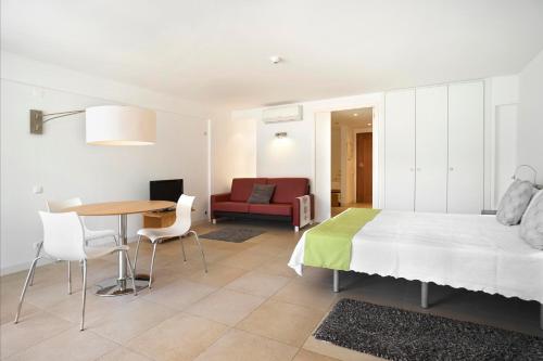 a bedroom with a bed and a table and a couch at Golden Club Cabanas in Cabanas de Tavira