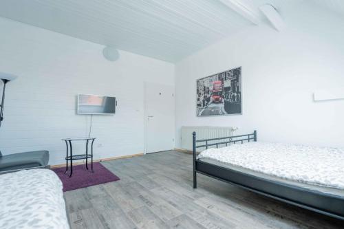 a bedroom with two beds and a table and a tv at FREYZEIT Apartment "Gässel" in der Altstadt von Speyer für bis zu 6 Personen in Speyer