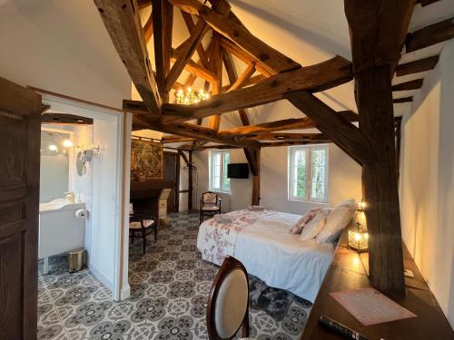 a bedroom with a bed in a room with wooden ceilings at Pavillon des communs in Bornel