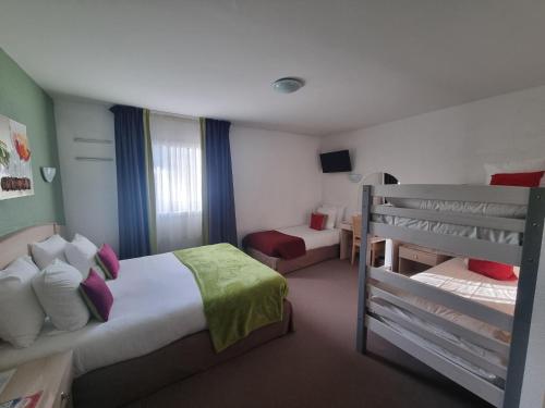 a hotel room with a bunk bed and a bunk bed at Hôtel Le Kolibri in Tournus