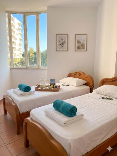 a room with two beds with towels on them at Marconi Apartments in Durrës