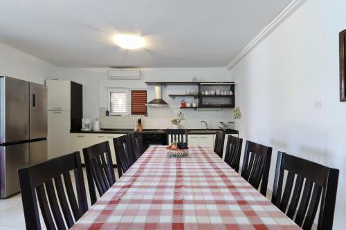 eine Küche mit Tisch, Stühlen und Kühlschrank in der Unterkunft Polaca in Kakma