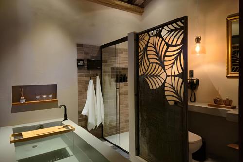 a bathroom with a shower with a glass door at Santo Cipó - Cabanas Românticas pertinho de BH - Privacidade total e vista deslumbrante in Jaboticatubas