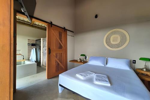 a bedroom with a bed and a bathroom with a tub at Santo Cipó - Cabanas Românticas pertinho de BH - Privacidade total e vista deslumbrante in Jaboticatubas