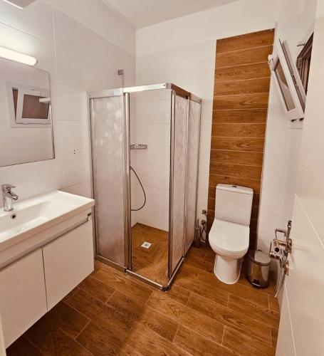 a bathroom with a shower and a toilet and a sink at MyGuest Cornelius 70 , 1-Bedroom Luxury Apartment in Iskele
