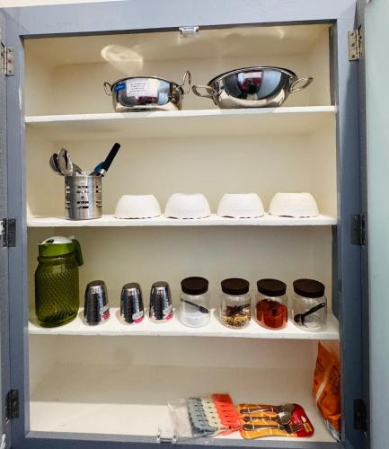a refrigerator shelf with pots and pans on it at Indigo Homes Kondapur in Hyderabad